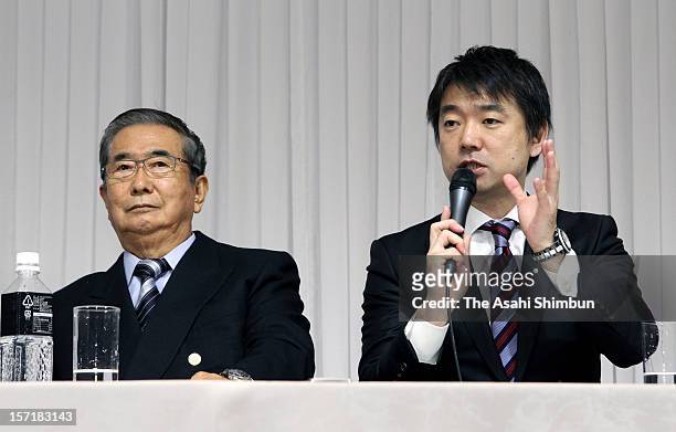 Japan Restoration Party acting president Toru Hashimoto speaks while their president Shintaro Ishihara listens during their campaign pledge...