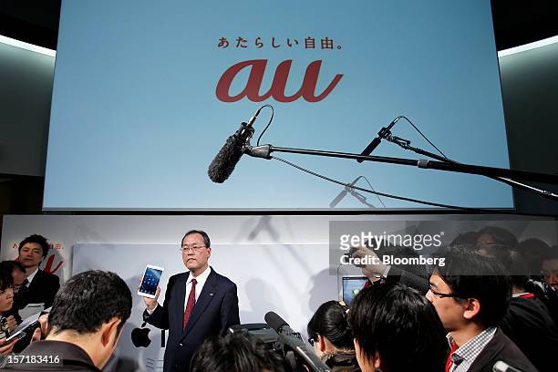 Takashi Tanaka, president of KDDI Corp., holds an Apple Inc. IPad Mini as he speaks to the media after a launch event at a KDDI store in Tokyo,...