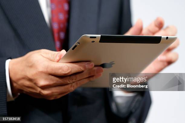 Takashi Tanaka, president of KDDI Corp., uses an Apple Inc. IPad during a launch event at a KDDI store in Tokyo, Japan, on Friday, Nov. 30, 2012. The...