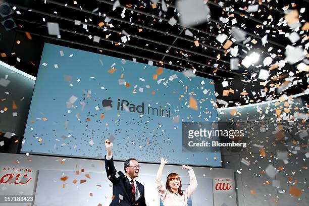 Takashi Tanaka, president of KDDI Corp., left, and actress Satomi Shigemori cheer during the launch of the Apple Inc. IPad Mini at a KDDI store in...