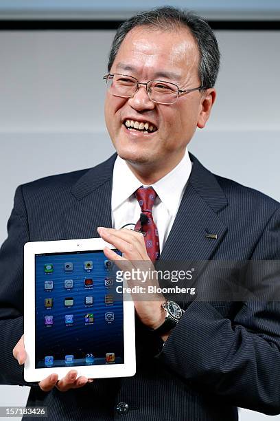 Takashi Tanaka, president of KDDI Corp., holds an Apple Inc. IPad during a launch event at a KDDI store in Tokyo, Japan, on Friday, Nov. 30, 2012....
