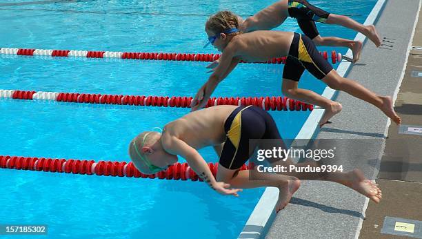 young boy スポーツ選手プールに飛び込むのレース - swimming tournament ストックフォトと画像