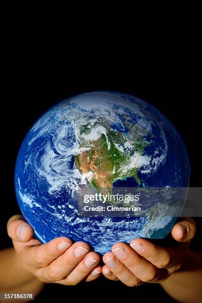 pair of hands holding the earth with north america visible - world hands stock pictures, royalty-free photos & images