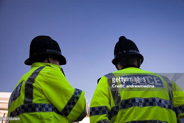 two british policemen wearing traditional helmets-click below for more. - manchester england stock pictures, royalty-free photos & images