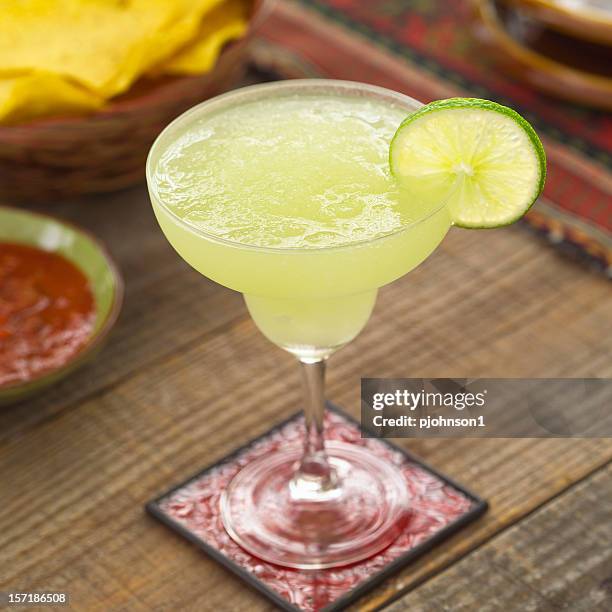 close-up of a glass of margarita on a red coaster - margarita stockfoto's en -beelden