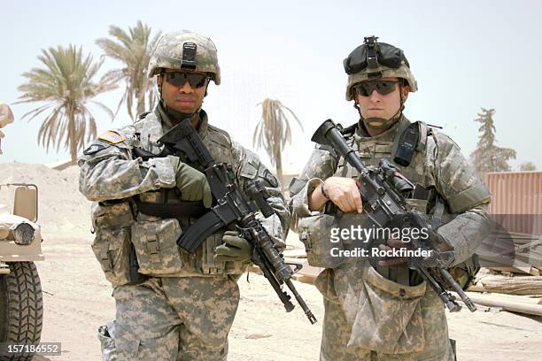 two soldiers posing on camera in the middle east - army soldier stockfoto's en -beelden