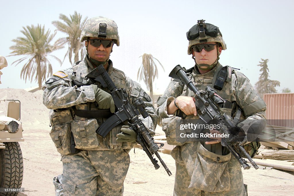 Two soldiers posing on camera in the middle east