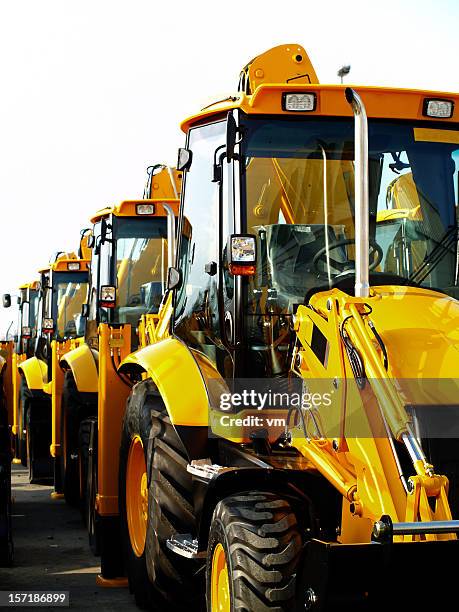 diggers in a row on industrial parking lot - construction equipment stock pictures, royalty-free photos & images