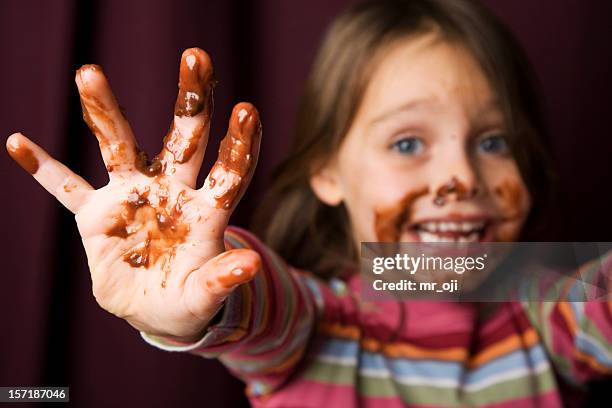 young girl covered in chocolate. - sticky fingers stock pictures, royalty-free photos & images