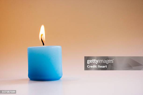 small blue lighted candle - candle vigil stock pictures, royalty-free photos & images