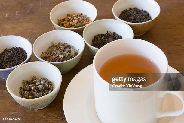 hot tea in cup near leaf varieties for tasting selections - tea leaf stock pictures, royalty-free photos & images