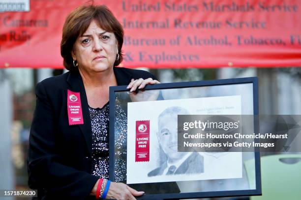 Mary Zapata, the mother of, slain immigration agent Jaime Zapata, holds a plaque depicting her son during the Enrique "Kiki" Camarena Red Ribbon...