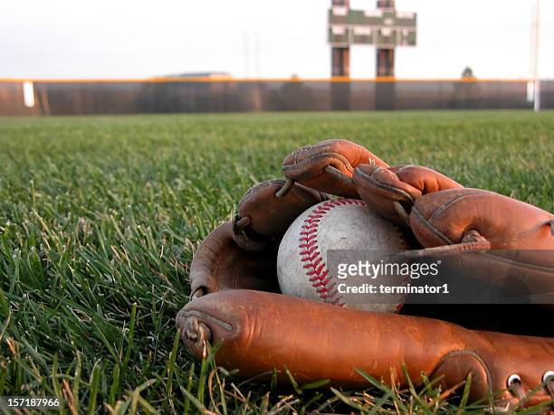 baseball-handschuh im gras - baseball scoreboard stock-fotos und bilder
