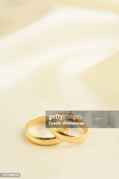zwei ringe auf weißem hintergrund - trauringe gold stock-fotos und bilder