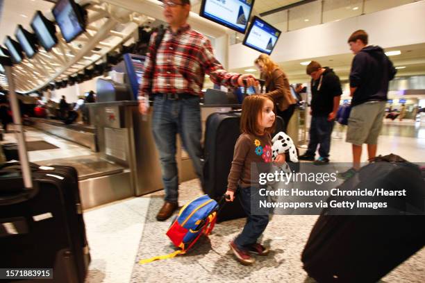 Erin Pilicer carries her luggage as her father Nihat checks-in their baggage before traveling to Virginia for the Thanksgiving holiday at Terminal C...