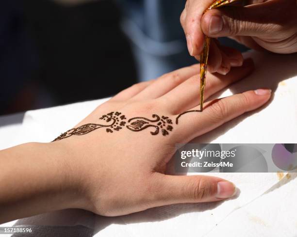 aplicando uma tatuagem temporária de henna - tatuagem de henna imagens e fotografias de stock