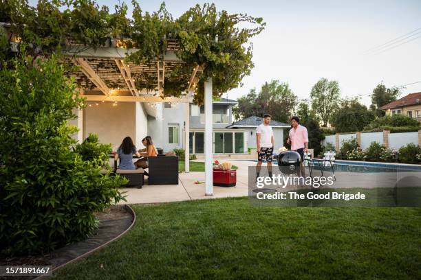 wide view of friends enjoying party at vacation rental - griglia per barbecue foto e immagini stock