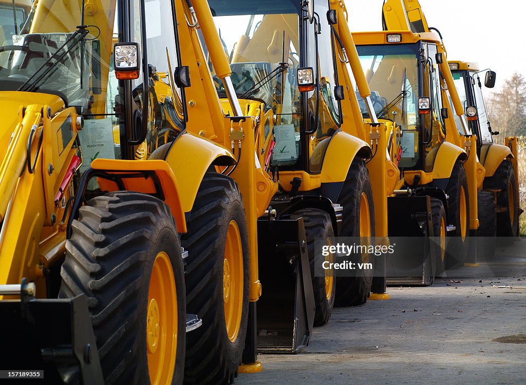 Diggers in una riga sul parcheggio industriale