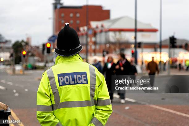 british policeman wearing tradtional  helmet observes people-see below for more - manchester england stock pictures, royalty-free photos & images