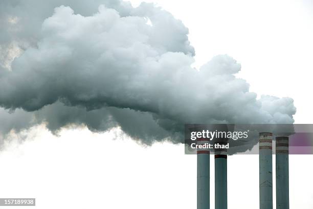 cuatro chimeneas y humo - chimenea industrial fotografías e imágenes de stock