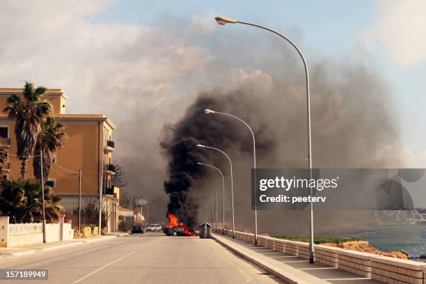 burning coche en la calle de la ciudad de sicilia. - terrorist fotografías e imágenes de stock