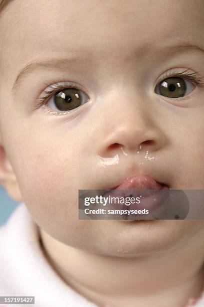 a cute sick baby with a runny nose with the tongue out - blowing nose stock pictures, royalty-free photos & images