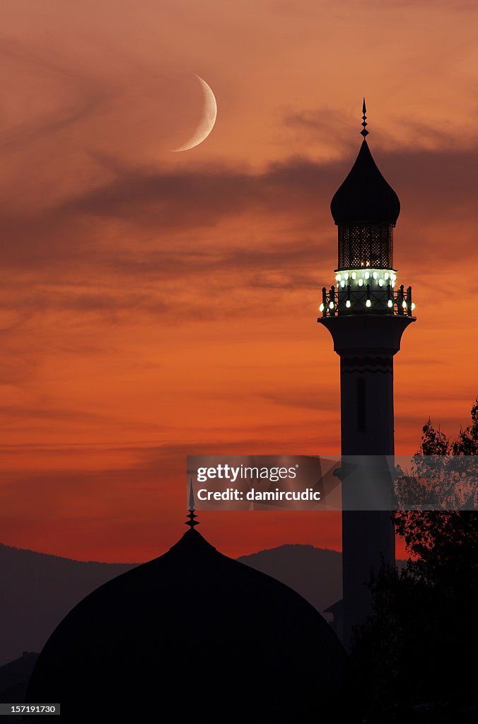 Mosque with crescent moon at dusk