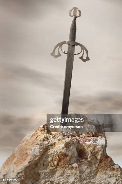 antique sword stuck in stone rock - excalibur stock pictures, royalty-free photos & images