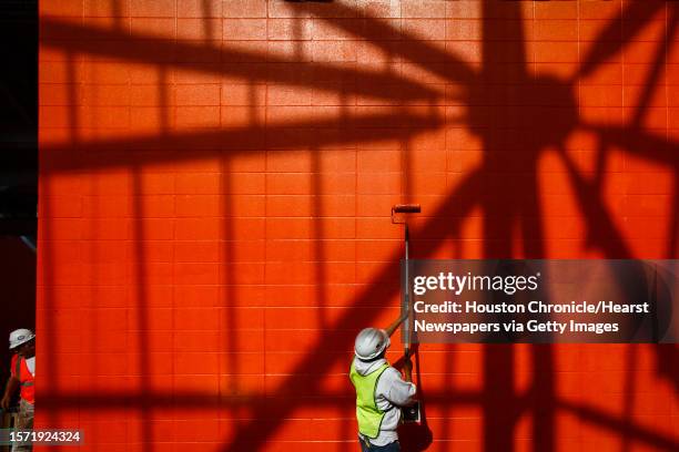 Workers paint a wall as seat installation, sod laying and general work continues at the BBVA Compass Stadium where the Houston Dynamo soccer team...