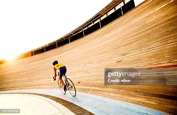 ciclista en pista velódromo riding hacia la noche de sol - sports track fotografías e imágenes de stock