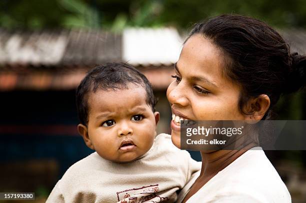 sri-lankische lächelnde junge frau mit einem baby im freien - sri lankische kultur stock-fotos und bilder