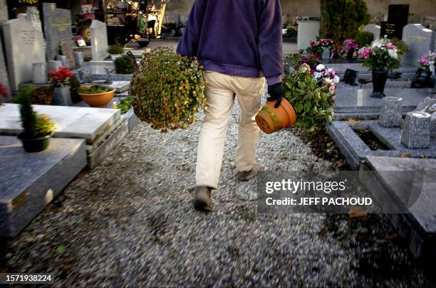 Funerary monumental mason moves flowerpots, 12 December 2006 in Loyasse cemetery in Lyon. Un employé transporte des pots de fleurs le 12 décembre...