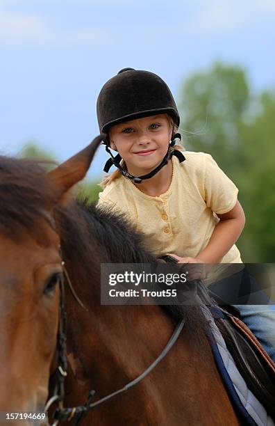 young girl with helmet riding a horse - animal riding stockfoto's en -beelden