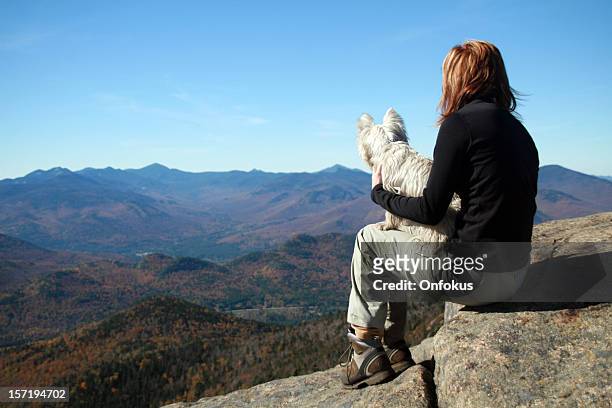 woman hiker and dog resting on mountain summit after hiking - adirondack state park stock pictures, royalty-free photos & images