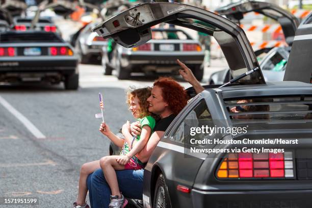 Gigi Larrabee gets her picture taken with Quin Woolley as they sit in a DeLorean during the 53rd Annual St. Patrick's Parade through downtown...