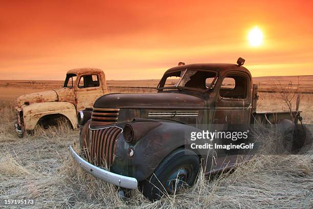 abandoned trucks on the prairie with sunrise - classic car restoration stockfoto's en -beelden