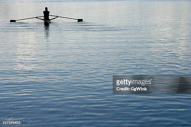 rear view of a man rowing a boat - single scull stockfoto's en -beelden