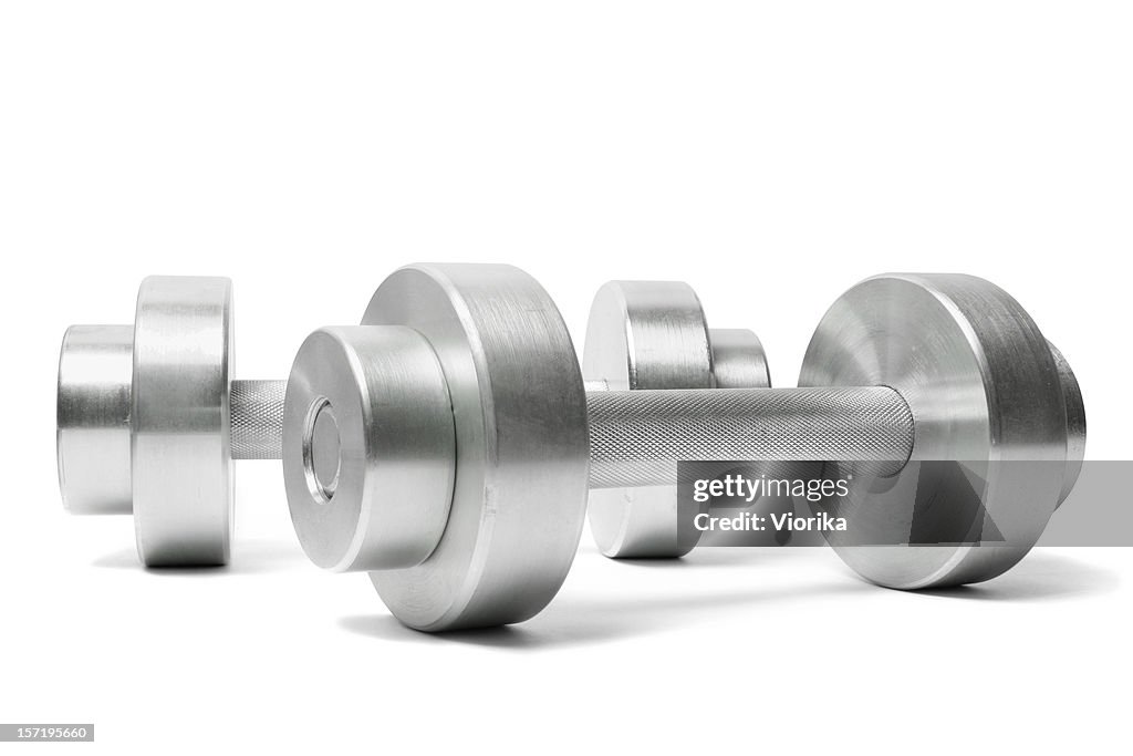 Two silver dumbbells sitting on a white table