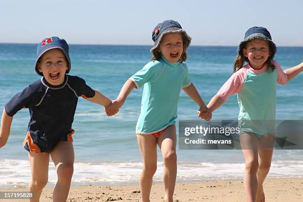 fun on the beach - triplets stock pictures, royalty-free photos & images