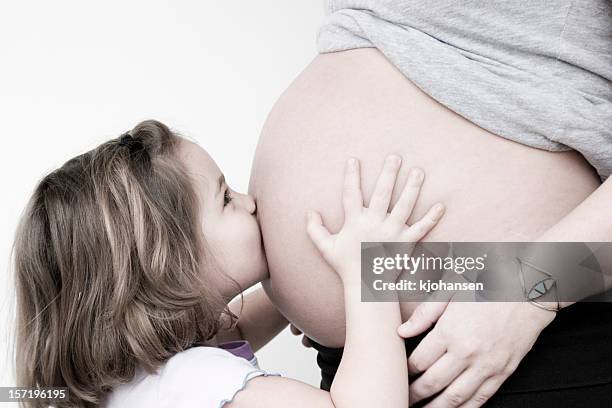 kissing her sister - belly kissing stock pictures, royalty-free photos & images