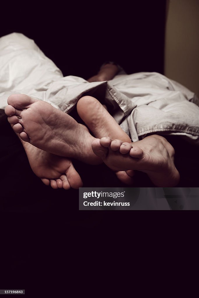 Vertical Portrait Feet Sticking Out of Bedding