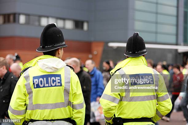 zwei britisch-polizisten-traditionellen helme – menschenmenge kontrolle. mehr unten. - british stock-fotos und bilder