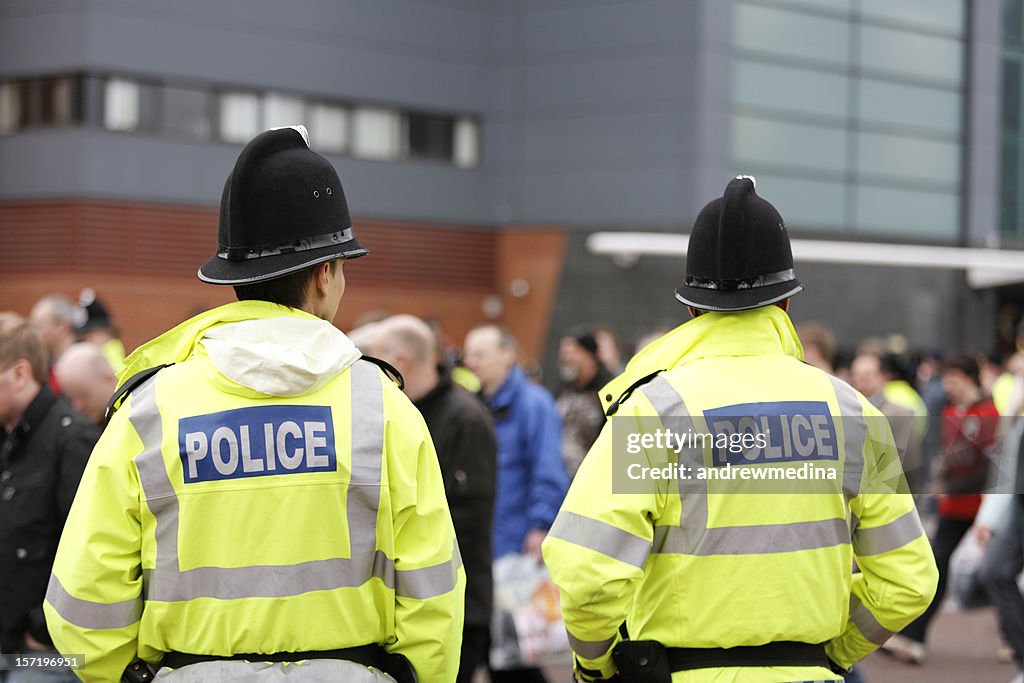 Due poliziotti britannico tradizionale caschi-folla di controllo. Più di seguito.