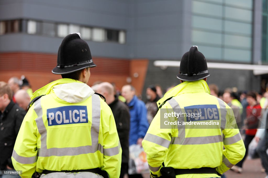 Due poliziotti britannico tradizionale caschi-folla di controllo. Più di seguito.