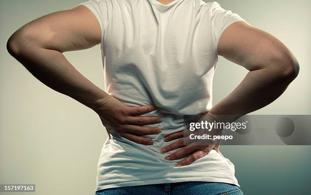 anonymous girl with back pain - rug handen zij stockfoto's en -beelden