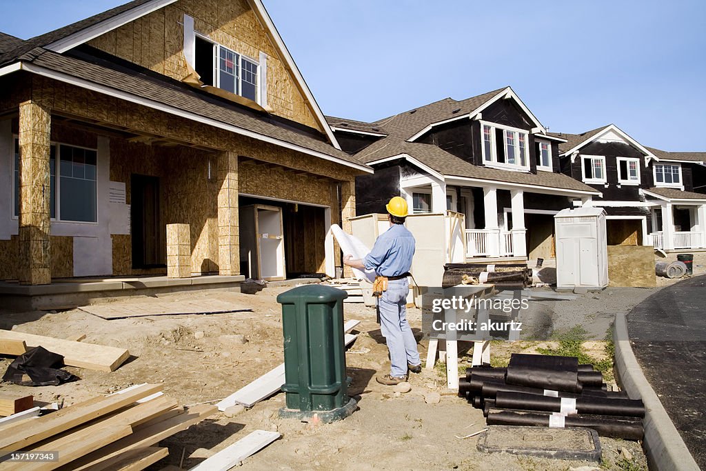 Man doing quality control inspection of a house being built