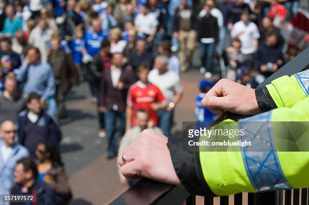 police officer watching over football fans crowd - guarding stock pictures, royalty-free photos & images