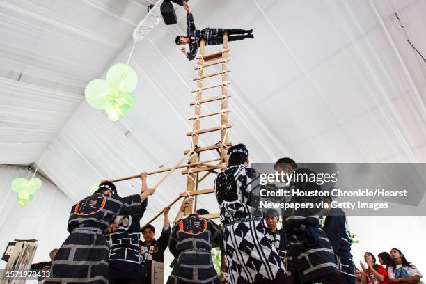 Members of the Naniwa Tobi Dento Hozonkai hold a 22ft ladder as Masayuki Watanabe balances on the top as the Osaka-based troupe performs acrobatics...