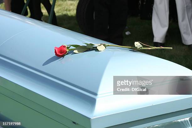 white funeral casket with a single red rode placed on top - funeral ceremony stock pictures, royalty-free photos & images