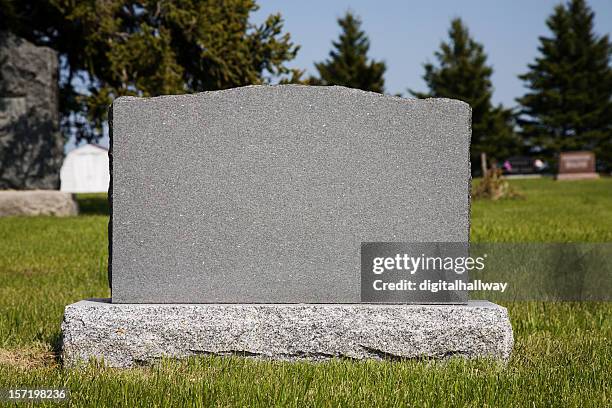 blank gravestone in grassy graveyard - grafsteen stockfoto's en -beelden